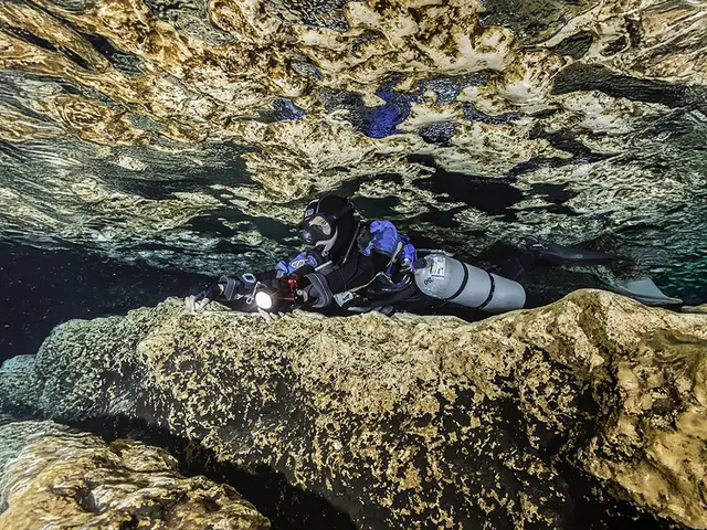 Plongeur en configuration sidemount sous un plafond rocheux