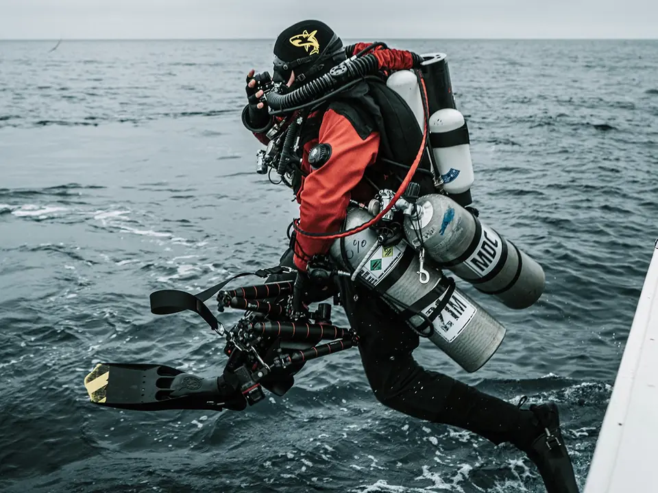 Plongeur équipé d'un recycleur Divesoft Liberty sautant d'un bateau