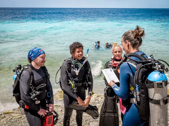 Instructeur de plongée en briefing avec ses élèves sur la plage