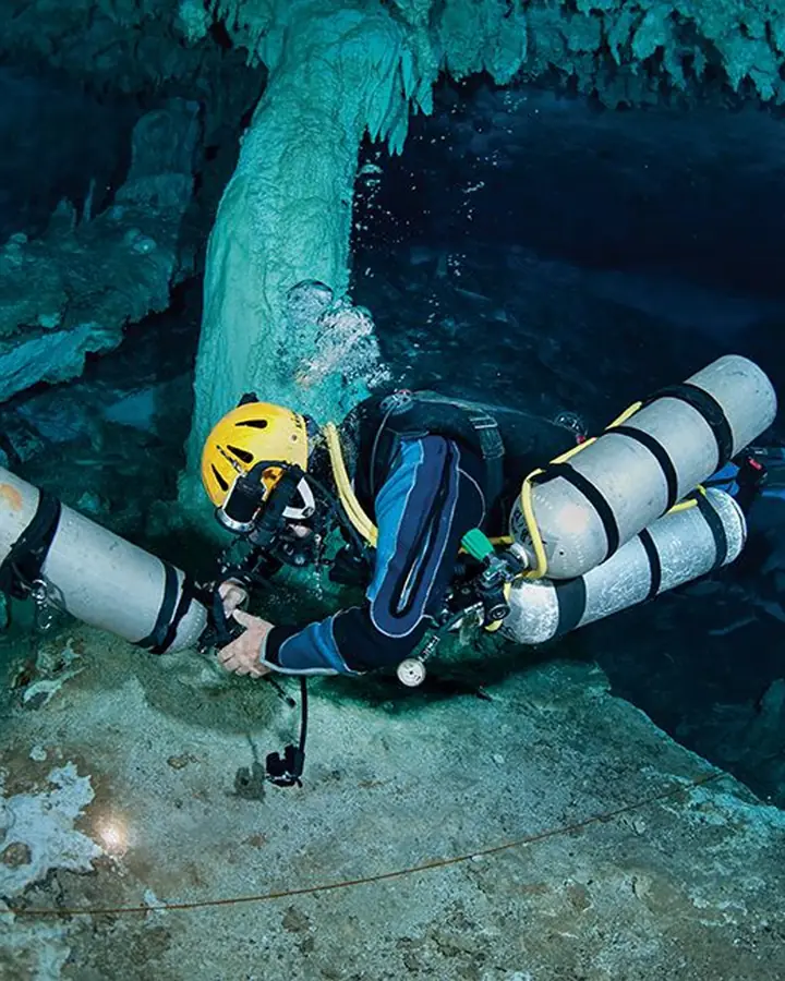 Plongeur technique avec bouteilles de décompression dans une grotte immergée